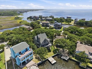 A coastal residential area with houses, a dock, and a river.