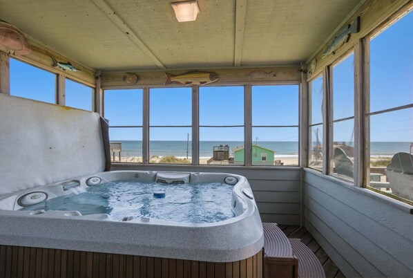 A hot tub with a view of the beach and ocean.