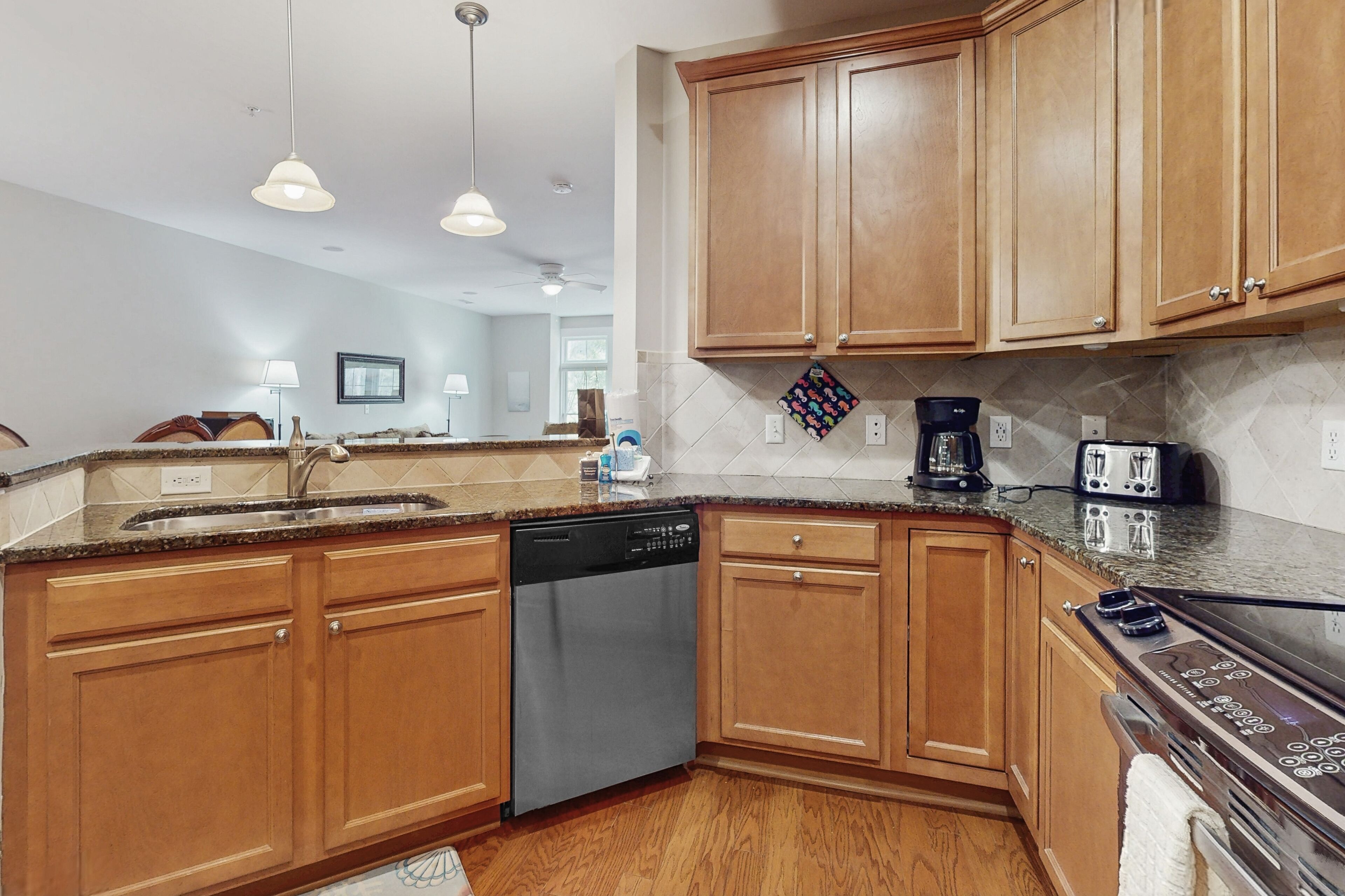 A modern kitchen with wooden cabinets, a dishwasher, a coffee maker, and a toaster.