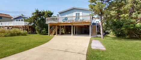 A two-story house with a covered patio and a concrete driveway.