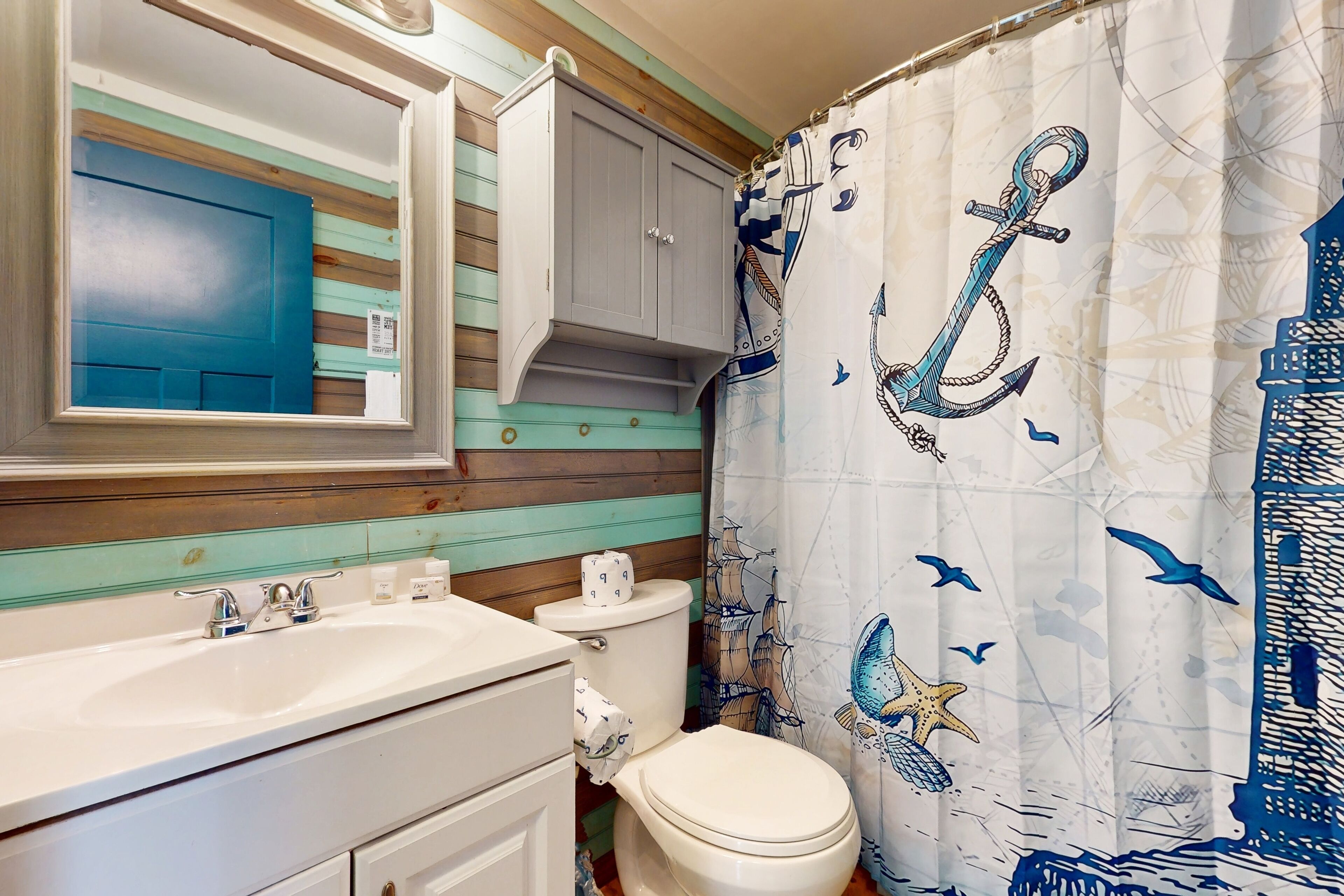 A bathroom with a white sink, a toilet, and a blue door.