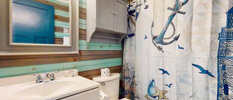 Un baño con un lavamanos blanco, un inodoro y una puerta azul.