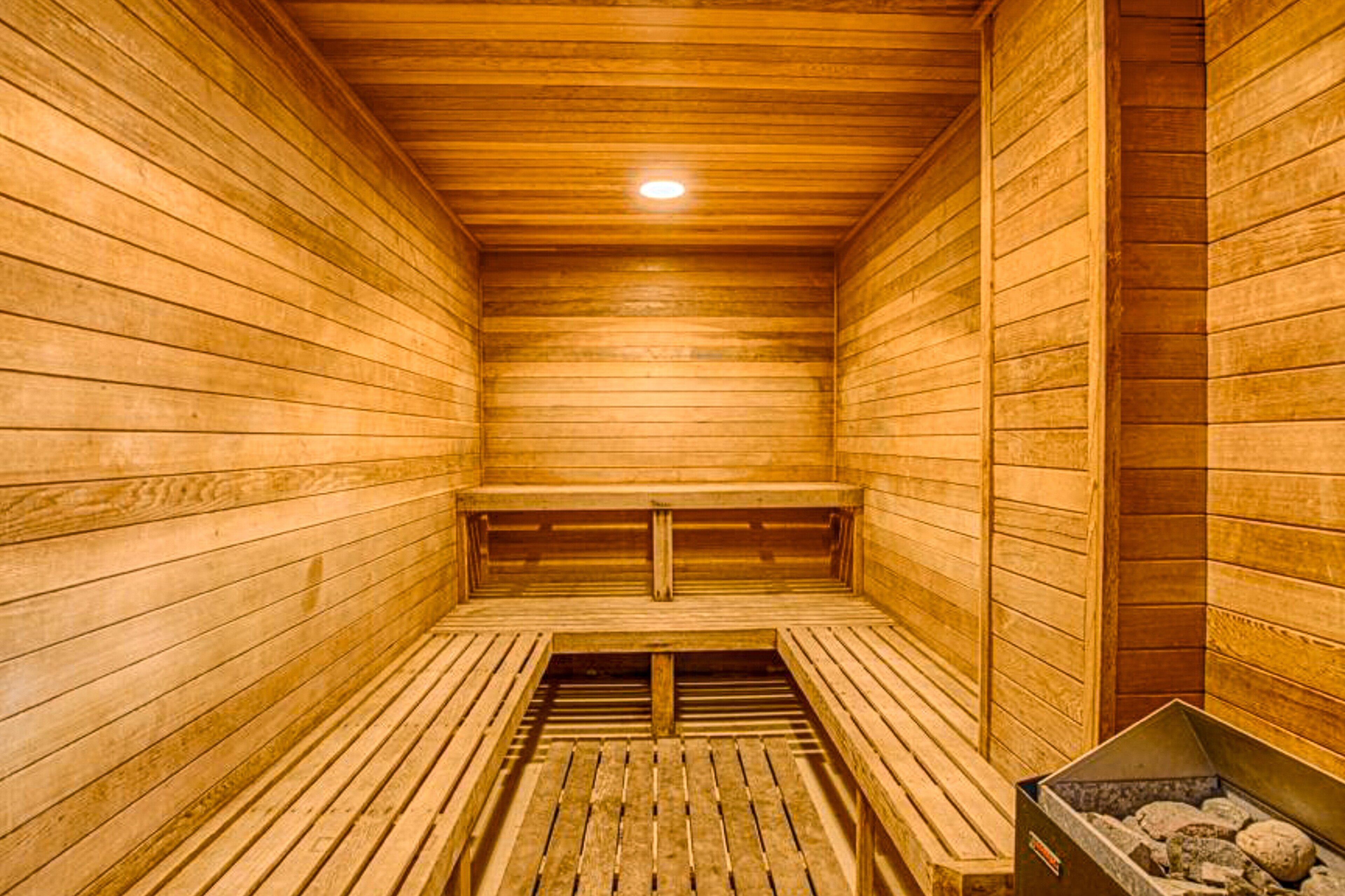 Un sauna en bois avec des bancs et une banquette.