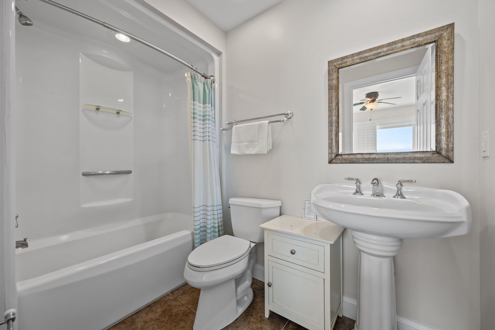 A bathroom with a bathtub, toilet, and sink.