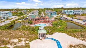 A beachfront hotel with a pool, beach access, and a view of the surrounding area.