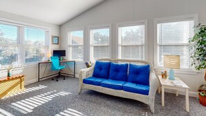A cozy room with a blue sofa, a desk, and a computer.