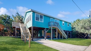 A two-story house with a covered porch and a small deck.