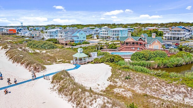 A coastal residential area with beachfront properties, a boardwalk, and a small pavilion. - STJ22B: Coastal Condo with golf course view and shared pool access (Southport)