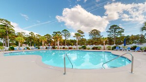 A swimming pool with a white fence and lounge chairs around it. - Coastal condo with golf course views, on-site pools, gym, & balcony (Calabash)