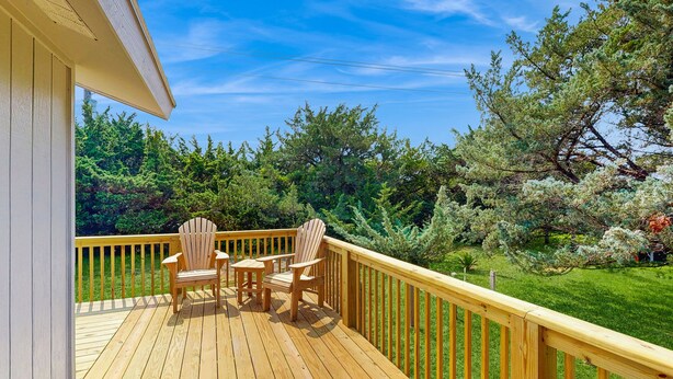 A wooden deck with two Adirondack chairs and a railing. - Bugler's Holiday 352: Single-level, sundeck, walk to the beach (Avon)