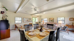 A dining area with a table set for four, surrounded by chairs, with a ceiling fan above and a window providing natural light. - Bugler's Holiday 352: Single-level, sundeck, walk to the beach (Avon)