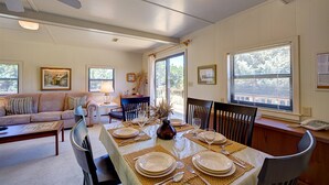 A dining area with a table set for four, a ceiling fan, and a window with blinds. - Bugler's Holiday 352: Single-level, sundeck, walk to the beach (Avon)