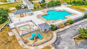 Una proprietà residenziale con piscina, area giochi per bambini e patio coperto.