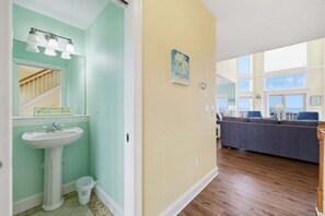A bathroom with a sink, mirror, and light fixture.