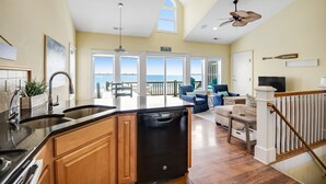A spacious kitchen with a dishwasher, wooden cabinets, and a view to the outside.