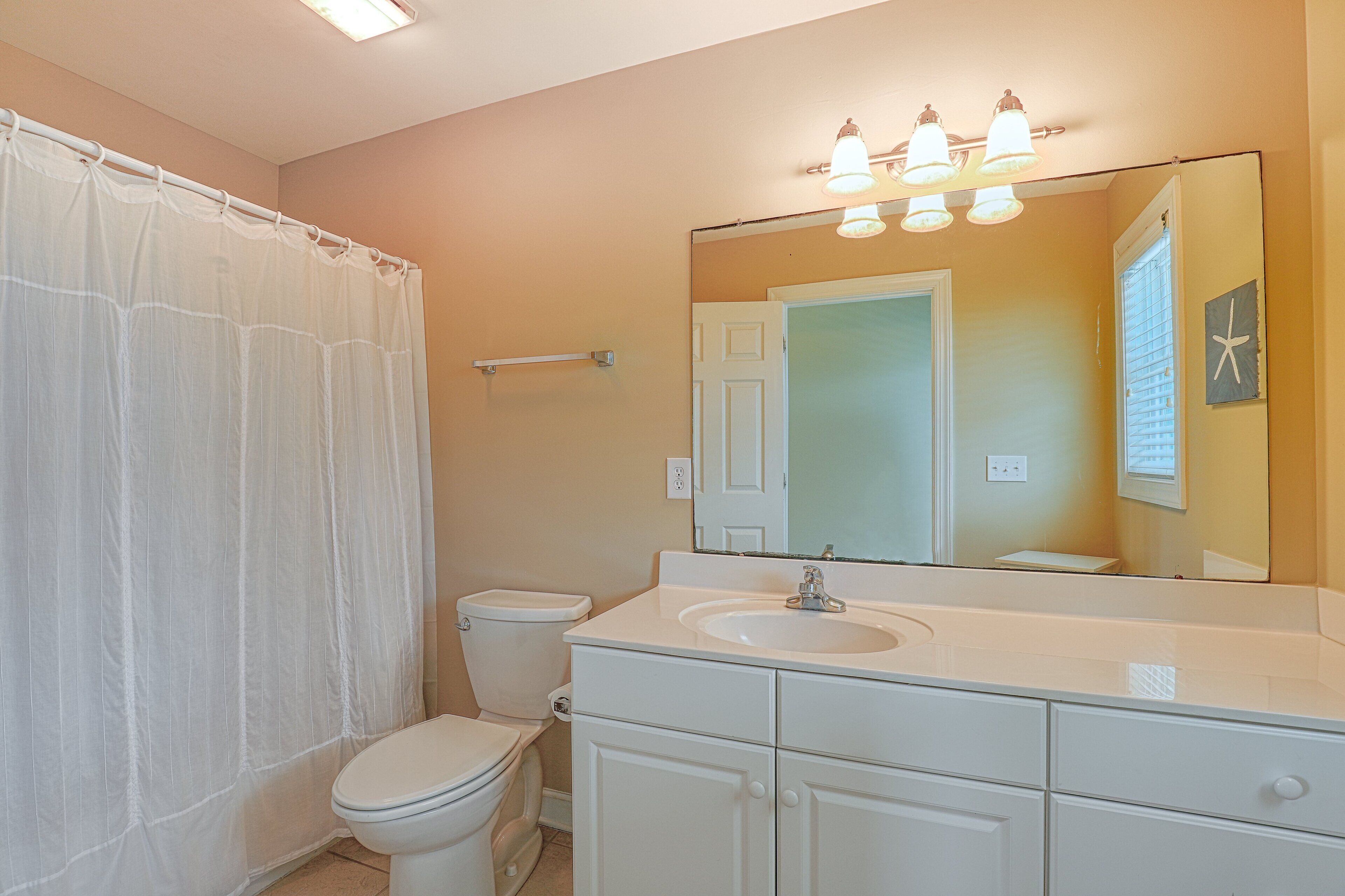 Une salle de bain avec des toilettes, un lavabo et un miroir.