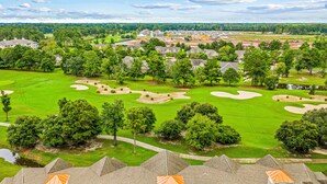 A golf course with sand bunkers and a residential area with houses and trees. - Crow Creek Retreat: Golf-course-front villa at Crow Creek with screened porch and washer/dryer (Calabash)
