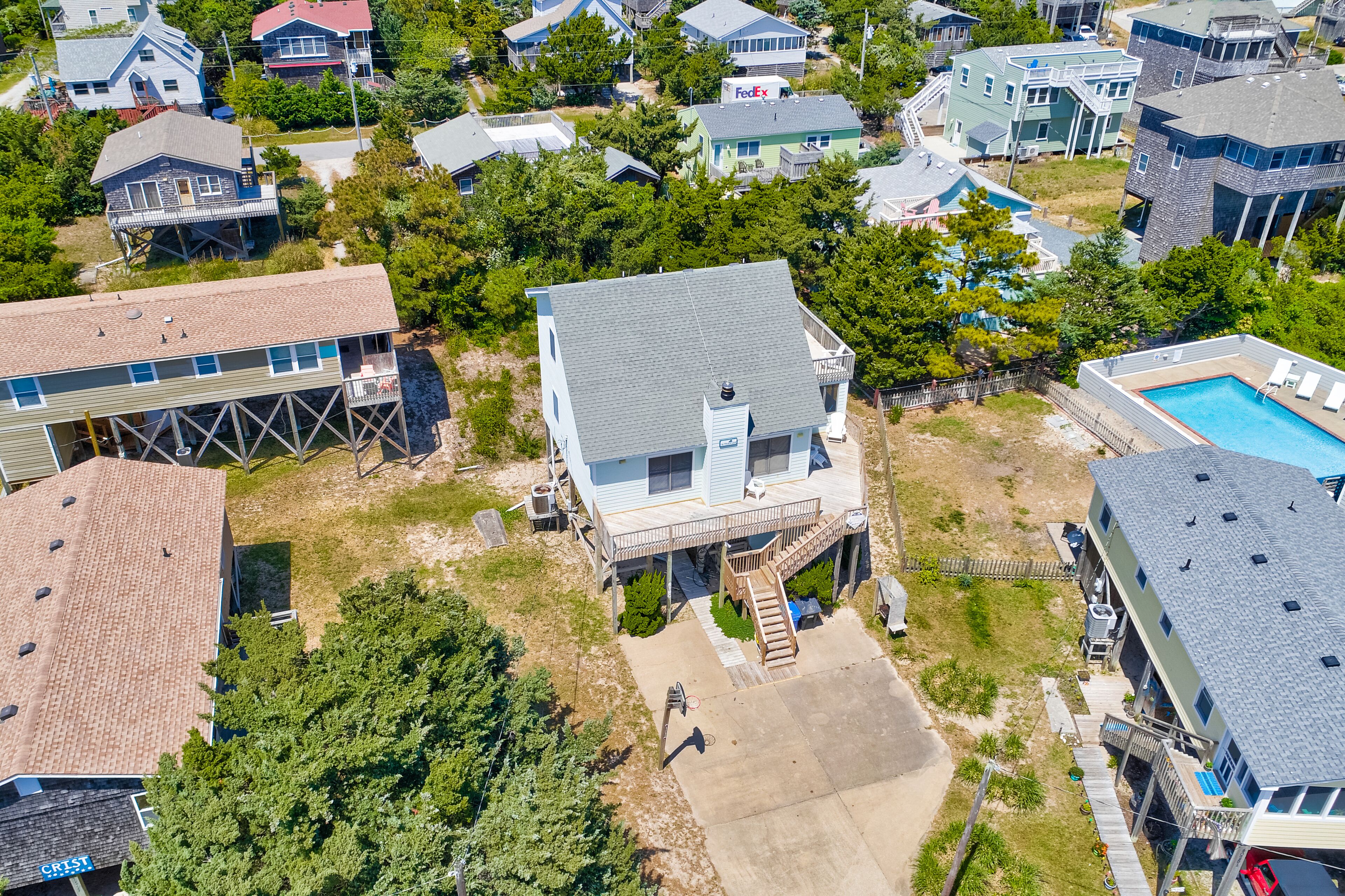 An aerial view of a residential area with houses, a swimming pool, and a dock.