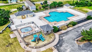 Un quartier résidentiel doté d’une piscine, d’un espace de jeux pour enfants et d’un petit bâtiment.