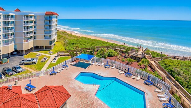 A hotel with a swimming pool, beach access, and a view of the ocean. - Oceanfront condo with pool, sauna, gym, game room, on-site restaurants, balcony (North Topsail Beach)