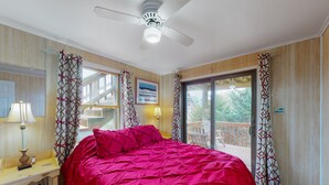 A bedroom with a bed, a desk, a chair, a ceiling fan, and a balcony with curtains. - Spacious dog-friendly house with shared pool, private hot tub, & central AC (Avon)
