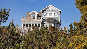 A two-story house with a balcony and a wrap-around porch. - Beautiful dog-friendly home overlooking the beach with hot tub, WiFi, & AC (Salvo)