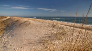 A beach with sand dunes and a clear view of the ocean. - Beautiful dog-friendly home overlooking the beach with hot tub, WiFi, & AC (Salvo)