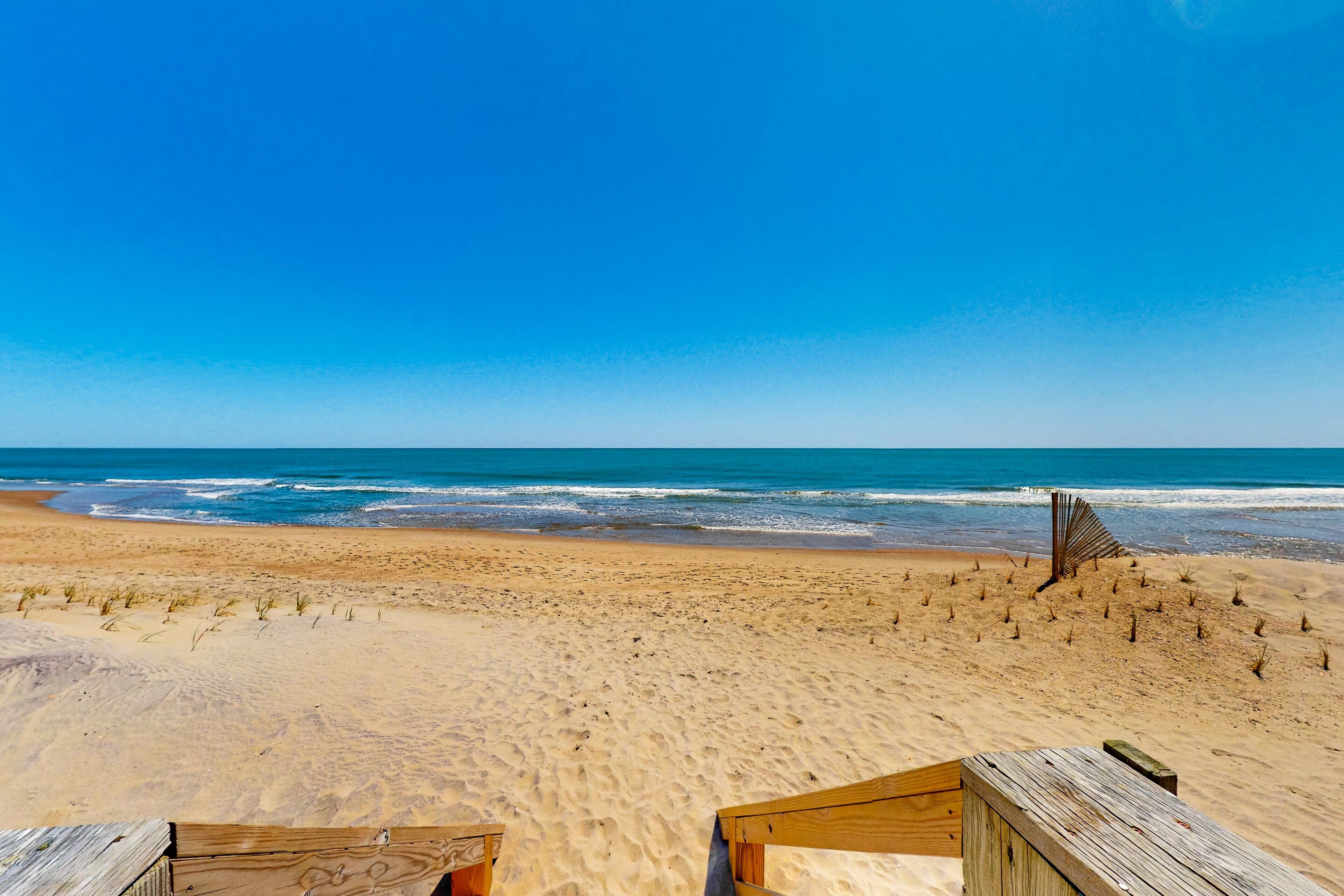 Una playa con estructuras de madera y una vista despejada del océano.