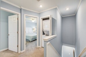 A bedroom with a bed, a nightstand, and a ceiling fan.