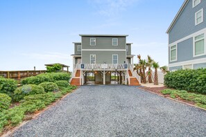 A two-story building with a covered entrance and a gravel driveway.