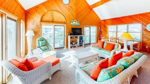 A cozy wooden interior with wicker furniture, a TV, and a sailboat decoration. - Stunning Family-Friendly Home w/ Free WiFi, Private W/D, AC, & Multiple Decks (Hatteras)
