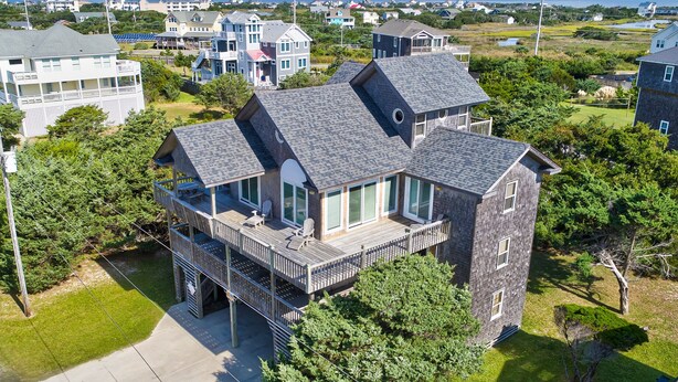 A multi-story house with a balcony, surrounded by greenery and other houses. - Stunning Family-Friendly Home w/ Free WiFi, Private W/D, AC, & Multiple Decks (Hatteras)