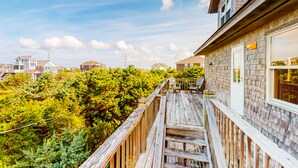 A wooden deck with a view of a residential area and trees. - Stunning Family-Friendly Home w/ Free WiFi, Private W/D, AC, & Multiple Decks (Hatteras)