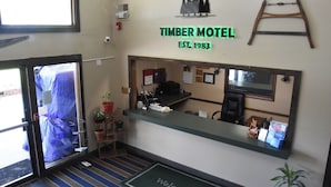 The interior of Timber Motel with a reception desk, a welcome mat, and a mirror reflecting the room. - Timber Motel (Clinton)