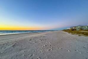 A beach with footprints leading to a house. - Island Dreams 4BR Retreat: Short walk to Beach with ocean views, pet-friendly (North Topsail Beach)