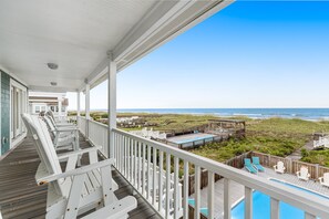 A wooden deck with white railings overlooking a beach and a pool area. - HB44 Bowery Break- Oceanfront, Private Pool, Exclusive walkway to the beach (Holden Beach)