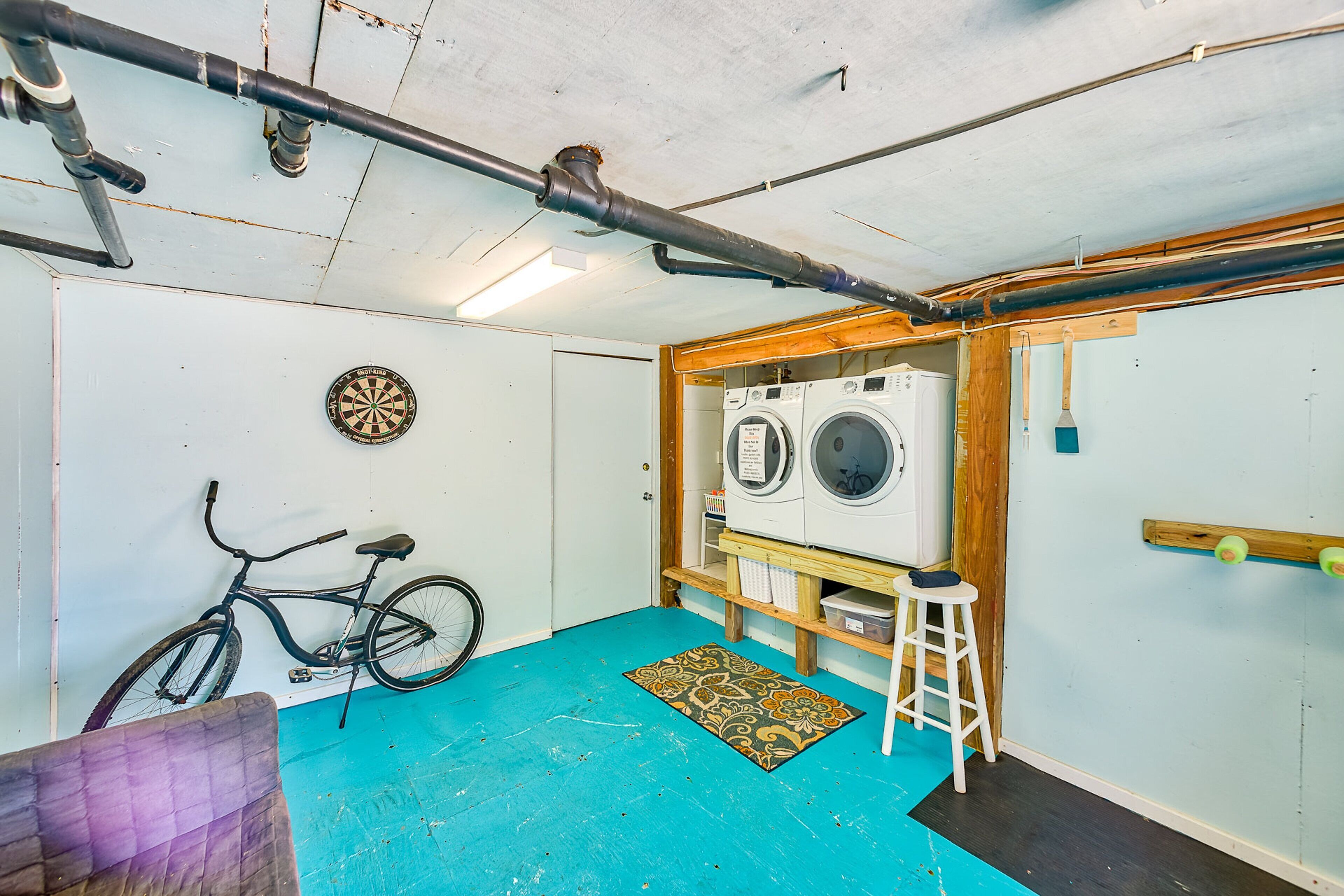 Un cuarto de lavado con lavadora, secadora y una bicicleta.