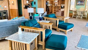 A cozy living room with a sofa, two ottomans, a coffee table, and a dining table with chairs. - Oceanfront Retreat, Stunning Views, Renovated Spaces, Game Room with Pool Table (Avon)