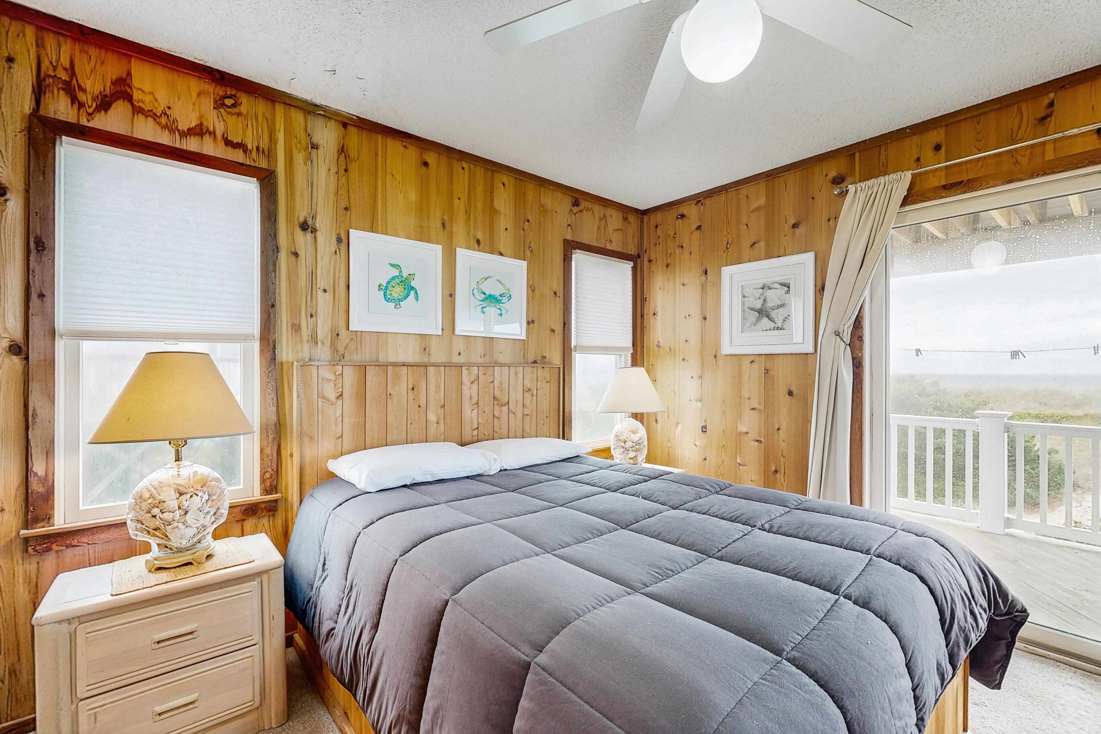 A bedroom with a large bed, wooden walls, and a balcony with a railing.