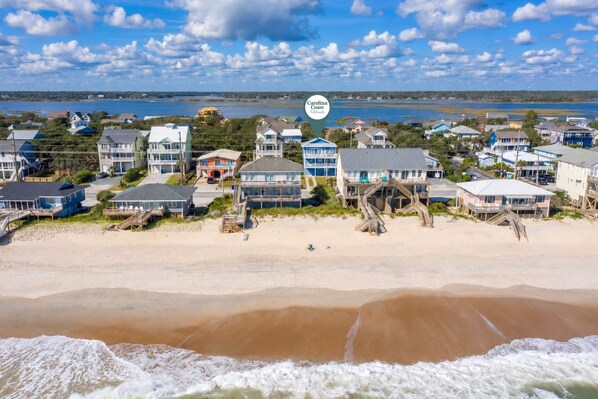 A coastal residential area with beachfront properties, including houses with balconies and beach access.