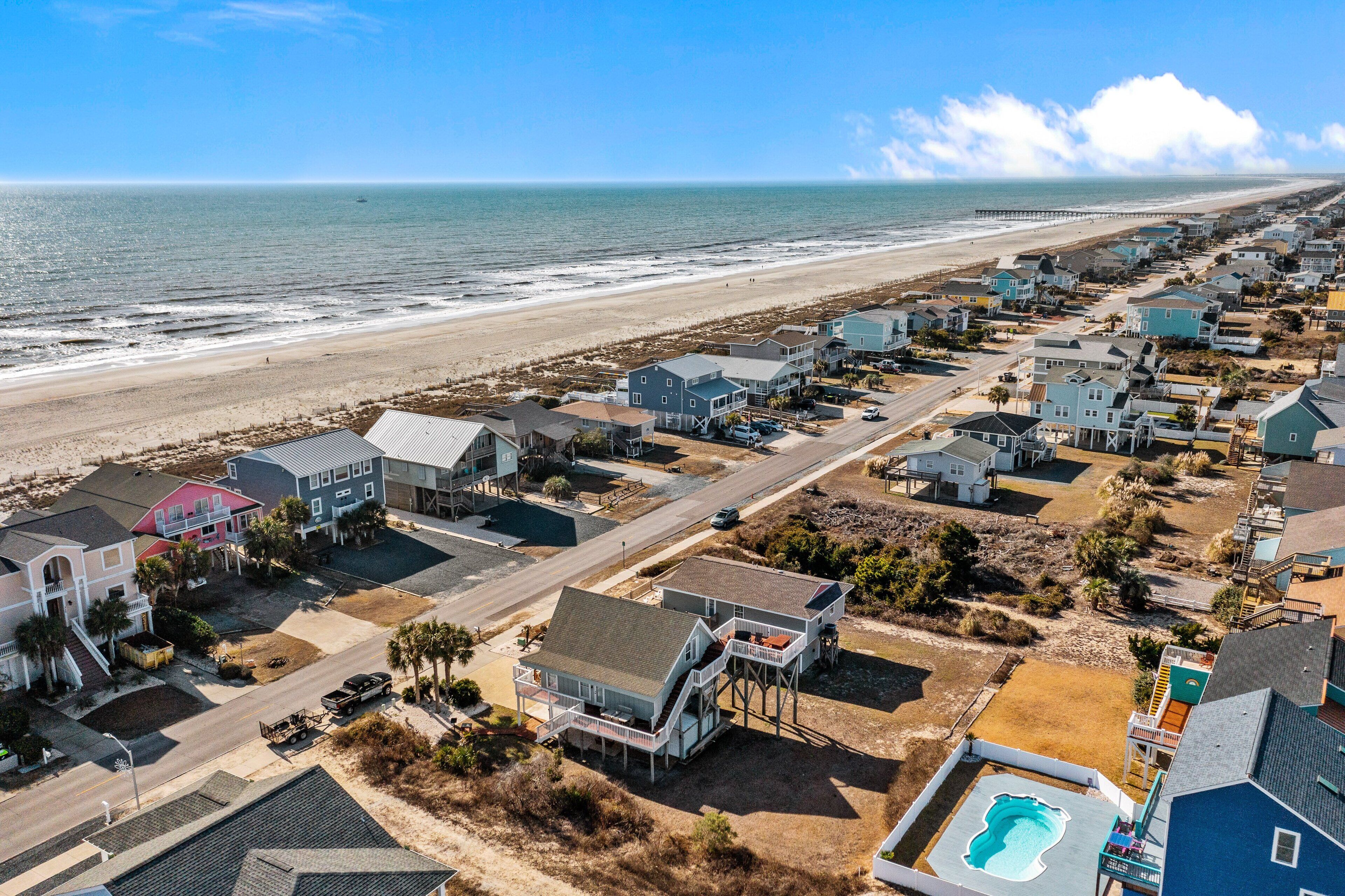 Une zone résidentielle côtière comprenant des maisons, une plage et une jetée.