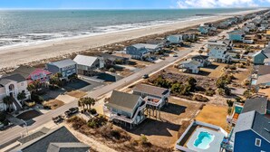 A coastal residential area with houses, a beach, and a pier. - Large and roomy house across from the beach with WiFi, W/D, central AC, and deck (Holden Beach)