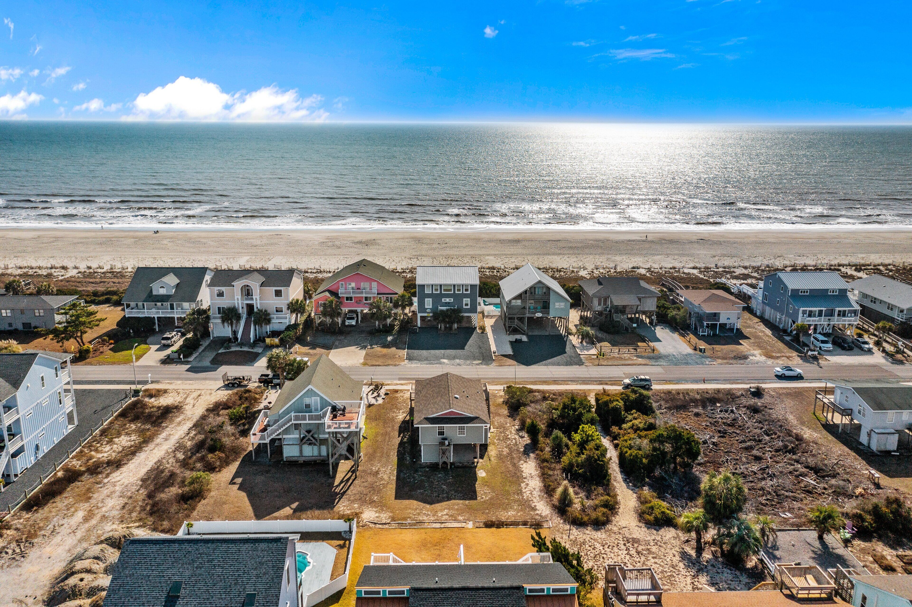 Une zone résidentielle côtière avec des maisons, une plage et un ciel dégagé.