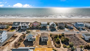 Une zone résidentielle côtière avec des maisons, une plage et un ciel dégagé.