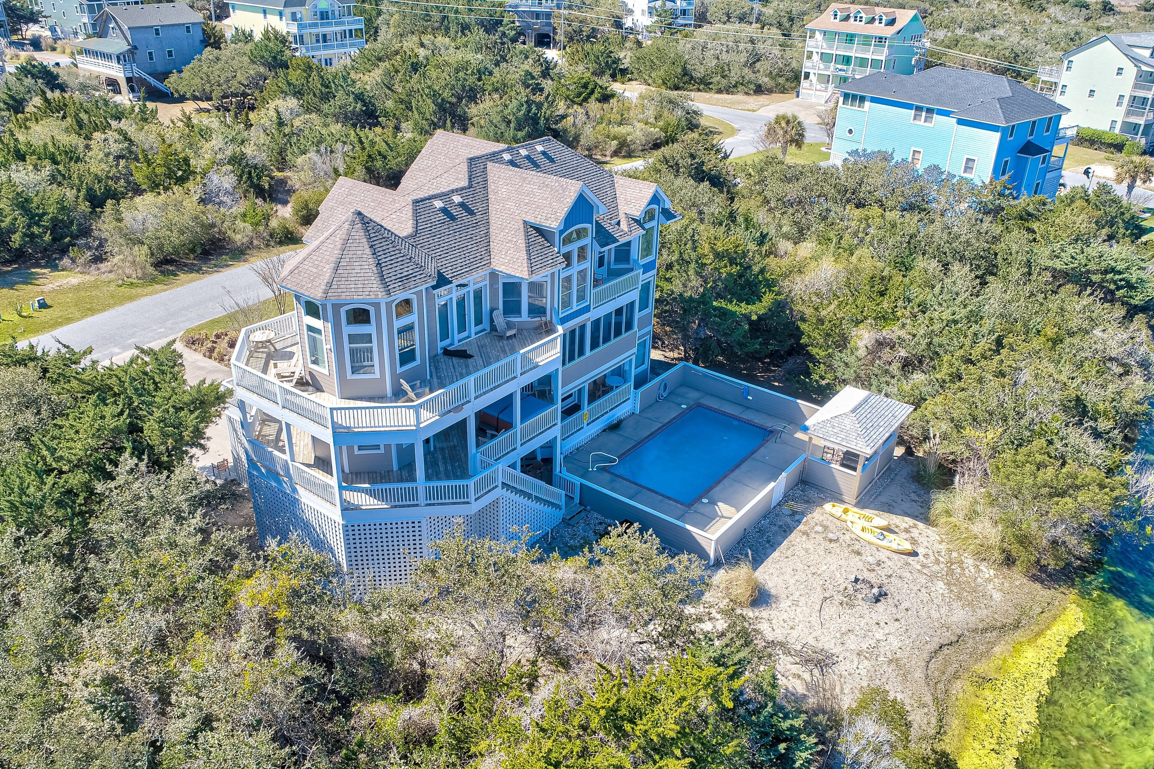 A multi-story house with a large balcony and a swimming pool.
