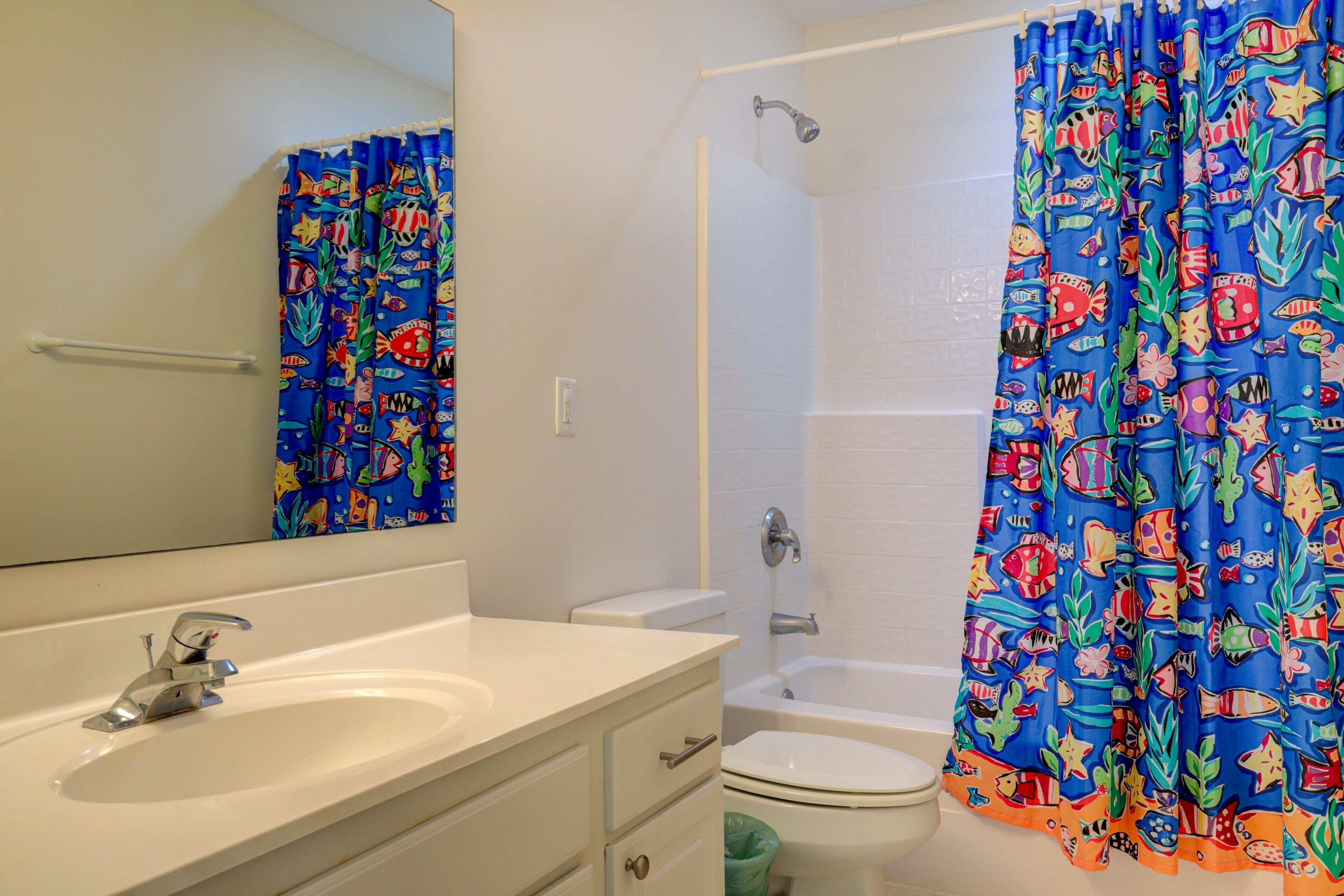 A bathroom with a white sink, a toilet, and a shower.