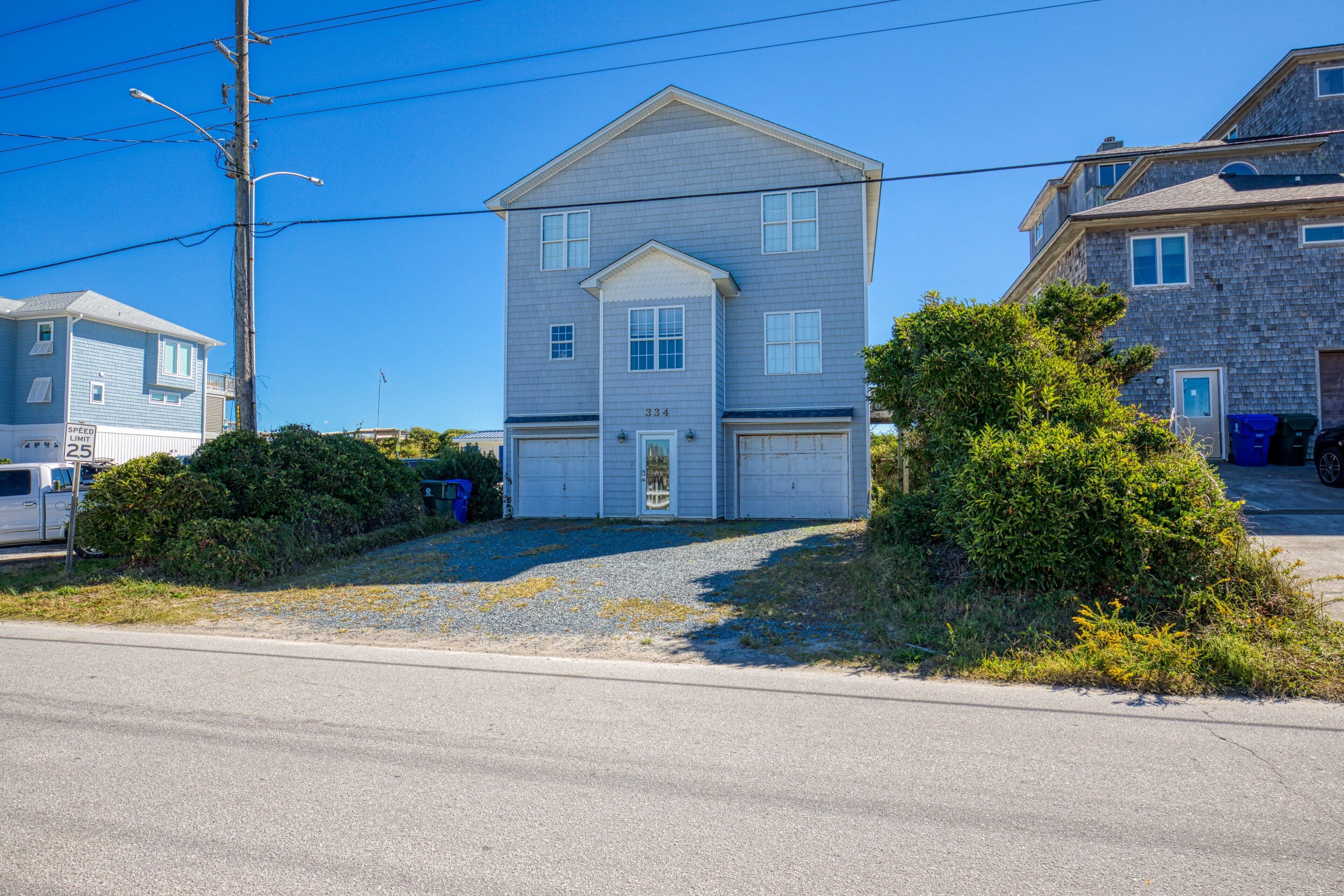 A two-story house with a garage, a well-maintained lawn, and a clear blue sky.