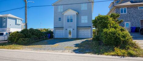A two-story house with a garage, a well-maintained lawn, and a clear blue sky.