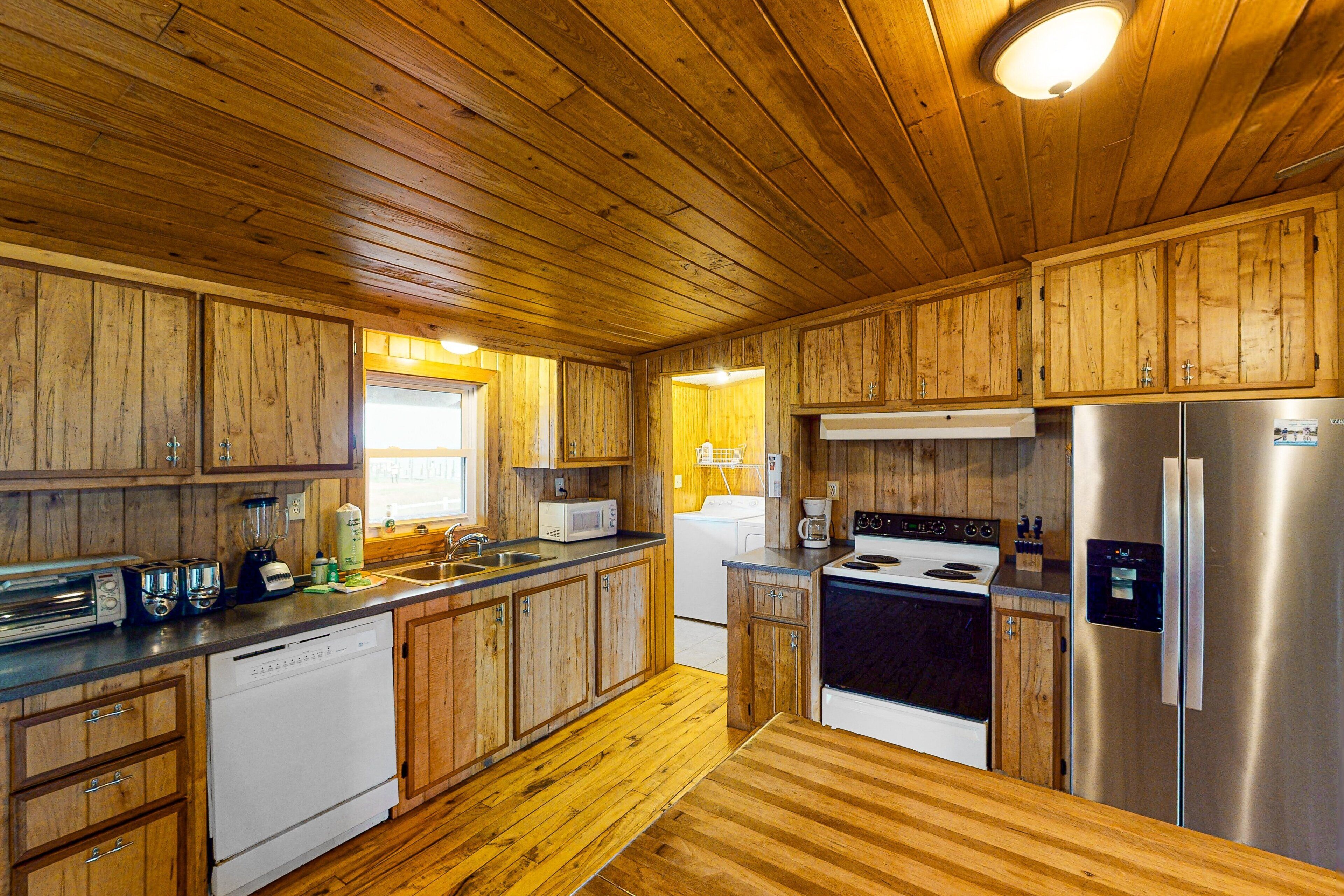 A kitchen with wooden cabinets, a dishwasher, a microwave, a stove, and a refrigerator.