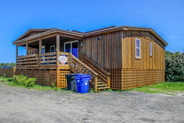 A wooden cabin with a porch and stairs leading to the entrance.